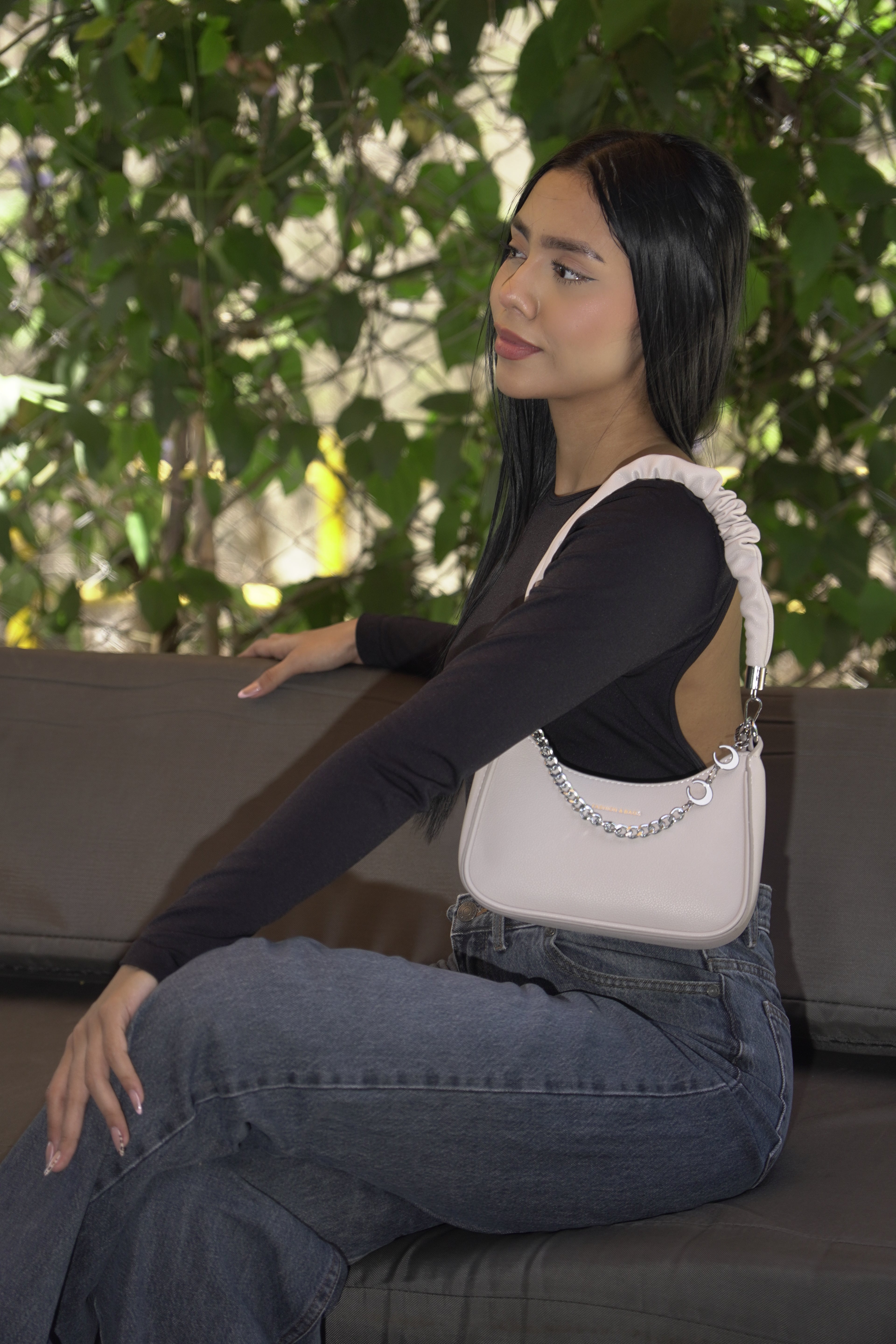 Mujer llevando bolso AURA lila al hombro con outfit negro - CALÉA