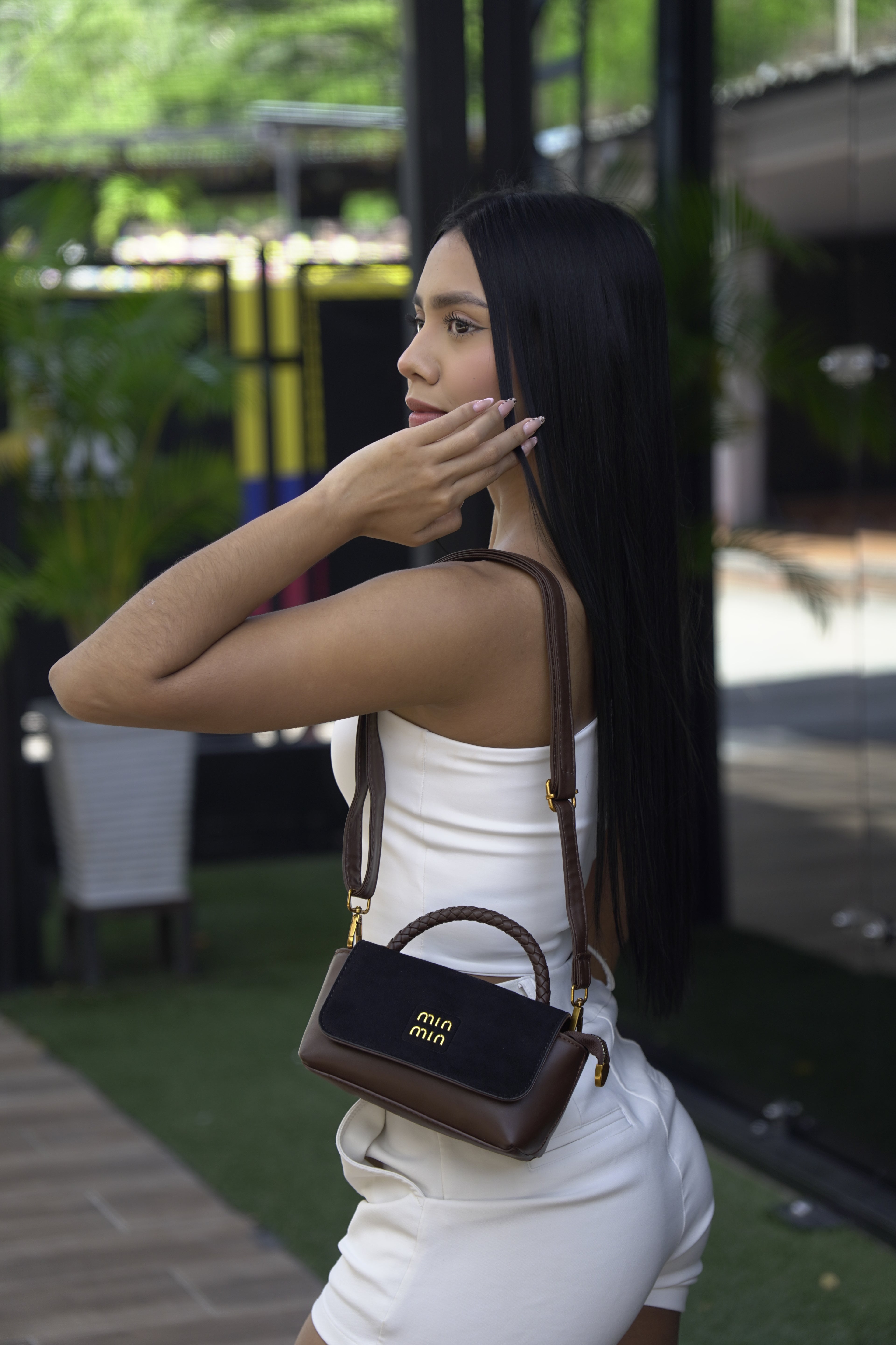 Mujer llevando mini baúl FALLON café negro como bolso manos libres - CALÉA