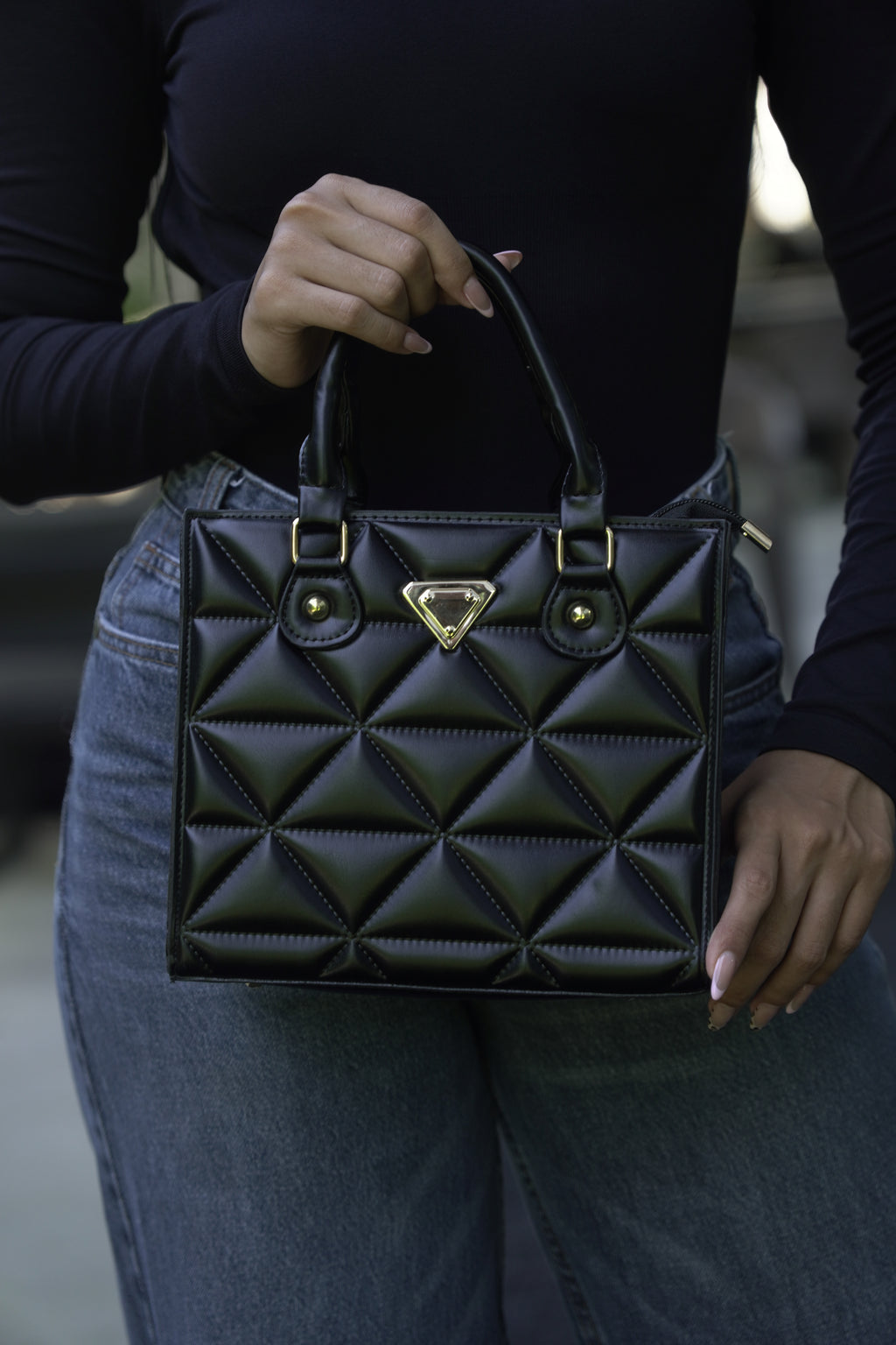 Detalle de bolso MILÁN negro acolchado con herrajes dorados - CALÉA