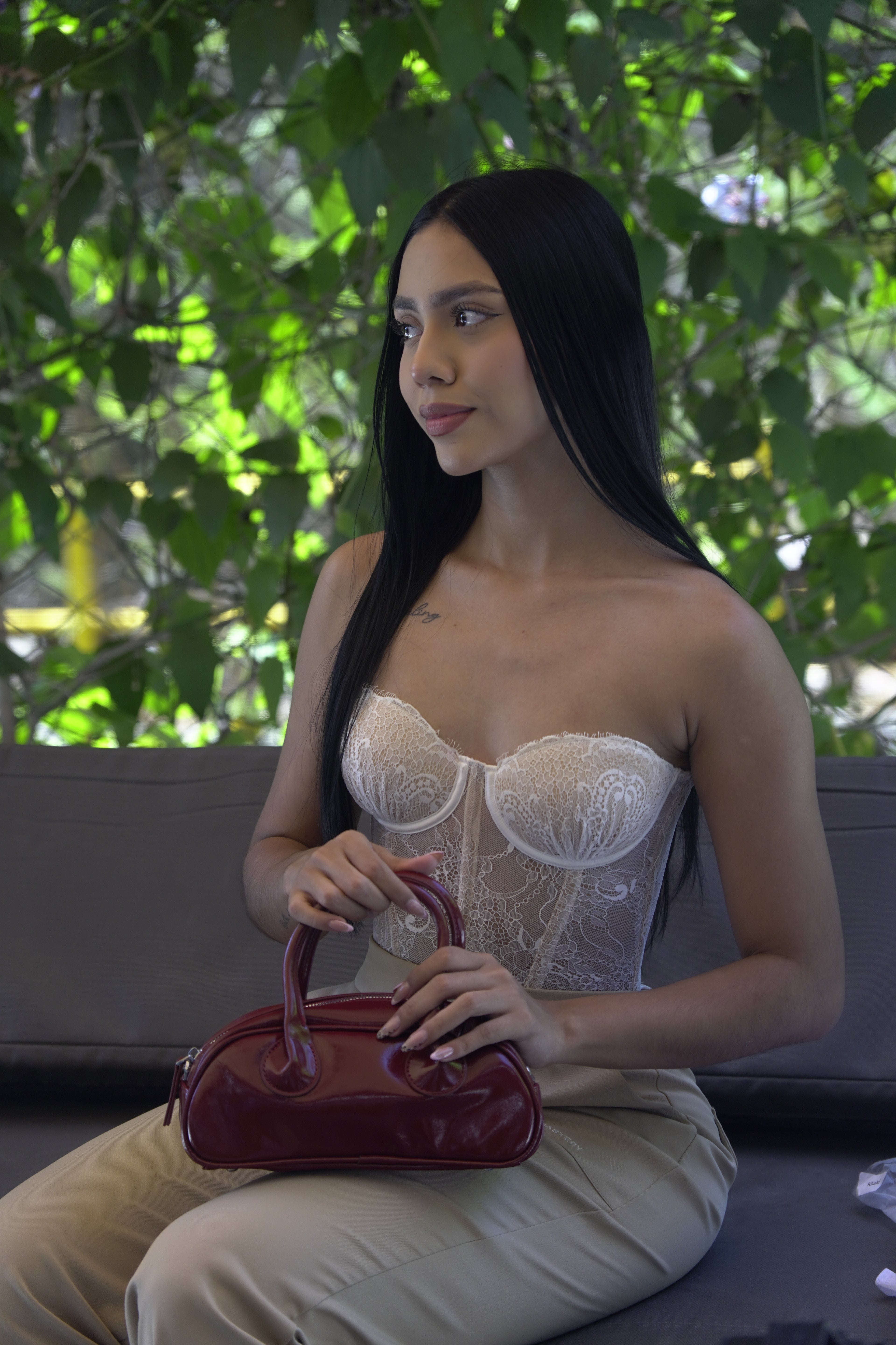 Mujer sosteniendo mini bolso TATIANA rojo vino estilo chic - CALÉA